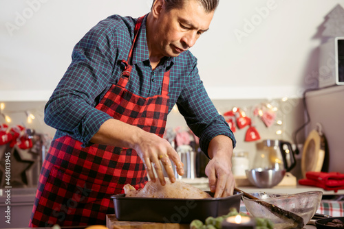 Mann stopft Geflügel und bereitet Essen für die Feiertage vor.