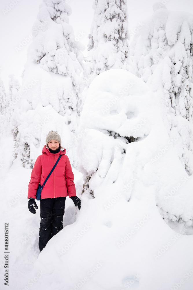 Fototapeta premium Cute girl in winter forest in Finland