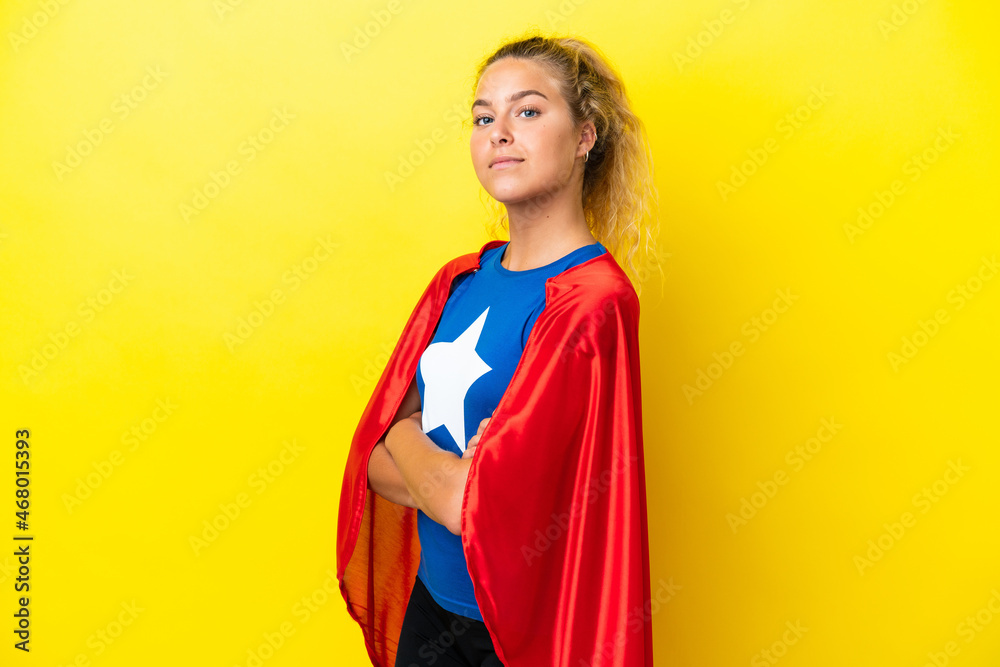 Girl with curly hair isolated on yellow background in superhero costume with arms crossed Girl with curly hair isolated on yellow background in superhero costume with arms crossed