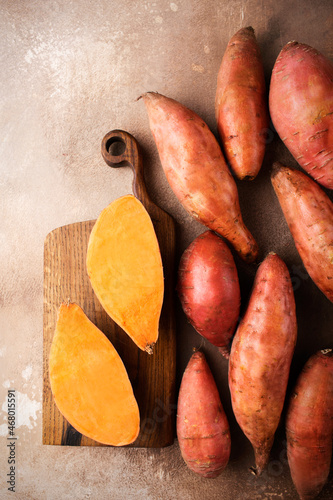 Sweet potato on a brown background. Exotic food. A fresh crop of vegetables. Raw sweet potato. Organic food