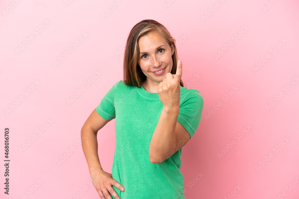 Young English woman isolated on pink background doing coming gesture Young English woman isolated on pink background doing coming gesture