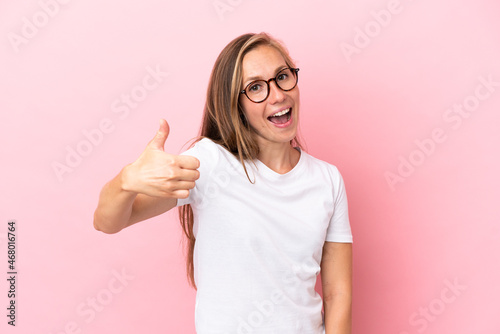 Young English woman isolated on pink background with thumbs up because something good has happened © luismolinero