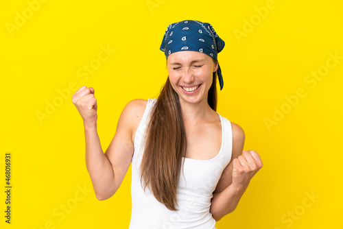 Young English woman isolated on yellow background celebrating a victory