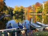 Bunte Bäume im Herbst am Teich mit Booten im Doblhoff Park in Baden bei Wien, Österreich