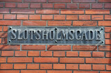 Altes Strassenschild Slotsholmsgade aus Metall auf Backsteinwand in Kopenhagen, Dänemark