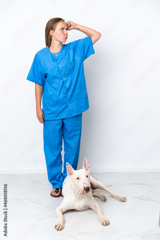 Young veterinarian English woman with dog isolated on white background having doubts and with confuse face expression Young veterinarian English woman with dog isolated on white background having doubts and with confuse face expression