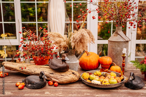 wooden table in the backyard of the house decorated in autumn style. 