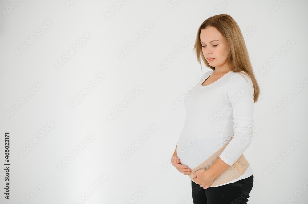 Woman puts on a bandage for pregnant women. Close-up. Woman puts on a bandage for pregnant women. Close-up.