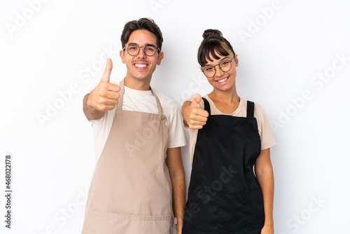 Restaurant mixed race waiters isolated on white background giving a thumbs up gesture because something good has happened