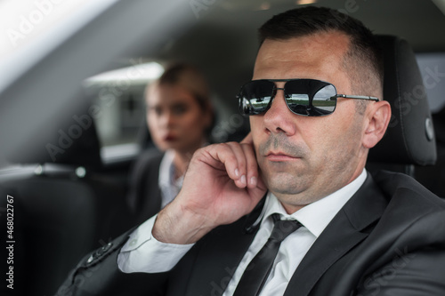 Agent with handsfree earpiece radio drive celebrity person in car © guruXOX