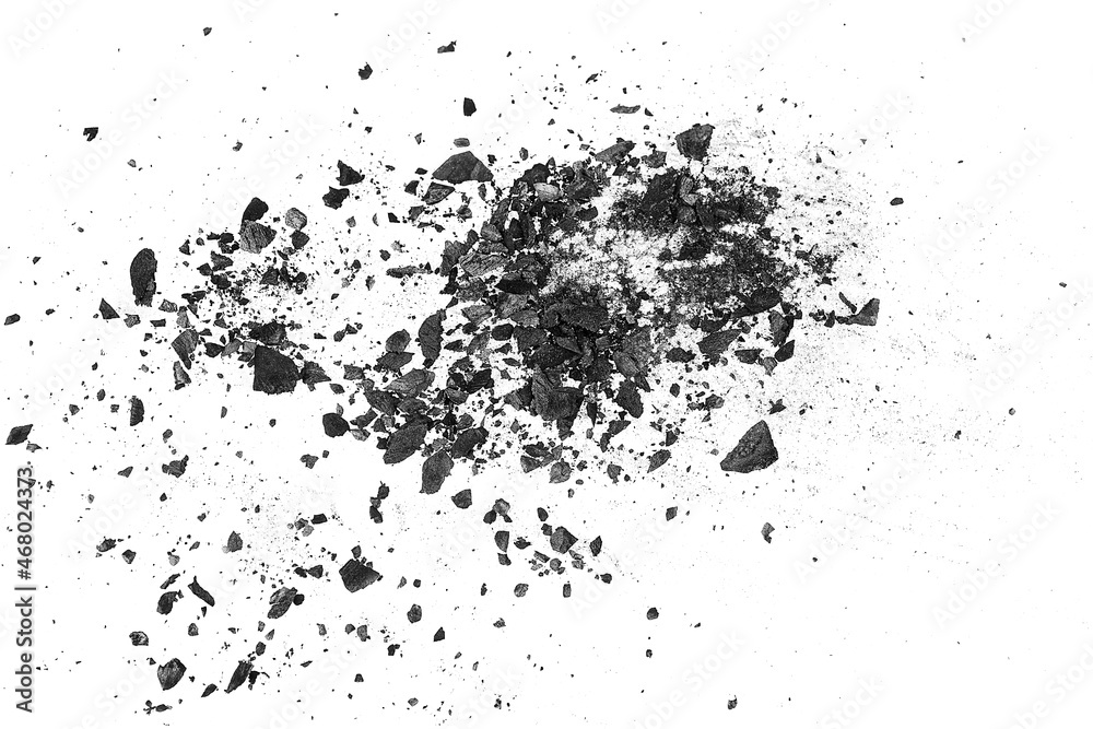 Black charcoal particles on a white background, top view. Activated charcoal powder.