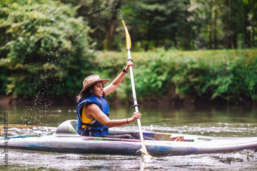 Woman in hat kayaking on river  photo