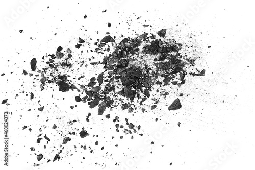 Black charcoal particles on a white background, top view. Activated charcoal powder.