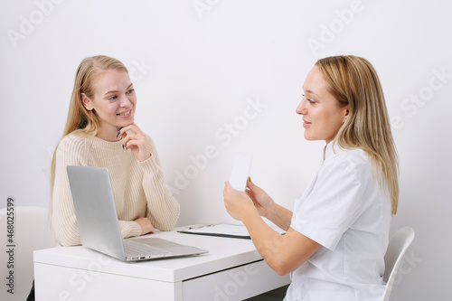 Consultation in cosmetology clinic. Female professional beauty doctor talking with pretty young female.