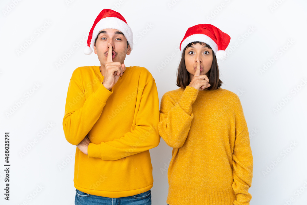 Young mixed race couple celebrating Christmas isolated on white background showing a sign of silence gesture putting finger in mouth Young mixed race couple celebrating Christmas isolated on white background showing a sign of silence gesture putting finger in mouth