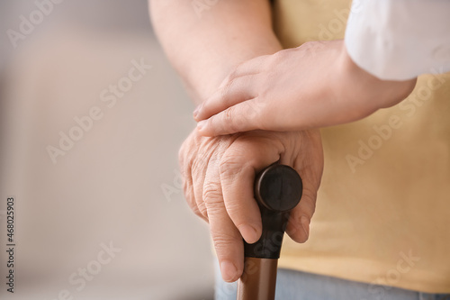 Hands of doctor and elderly woman at home