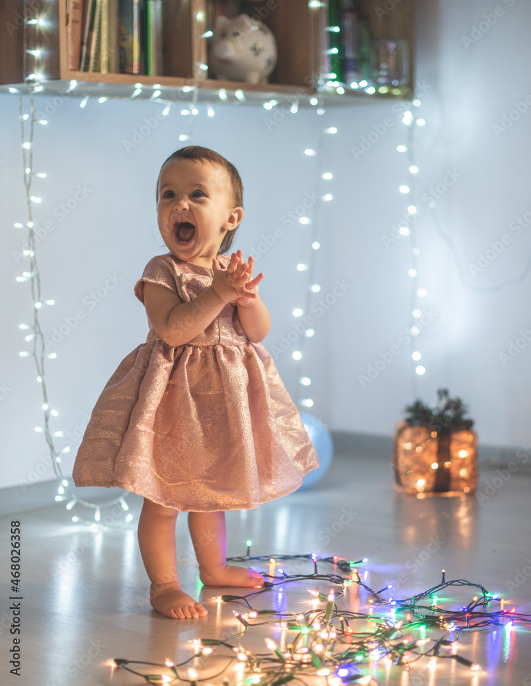 Little girl play with christmas lights