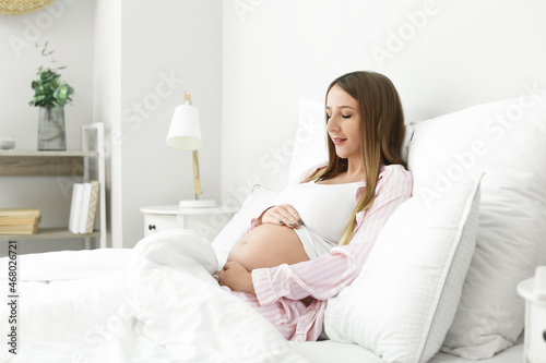 Young pregnant woman lying in bed