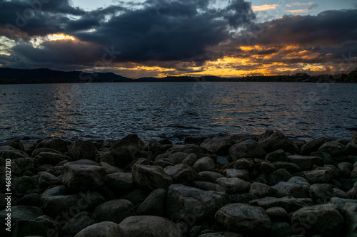 Steine ​​am Seeufer des Bodensees Sonnenuntergang mit kraftvollen Wolken am Himmel 