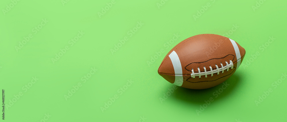 Leather american football on green background. Sport team concept. Horizontal sport theme poster, greeting cards, headers, website and app Leather american football on green background. Sport team concept. Horizontal sport theme poster, greeting cards, headers, website and app