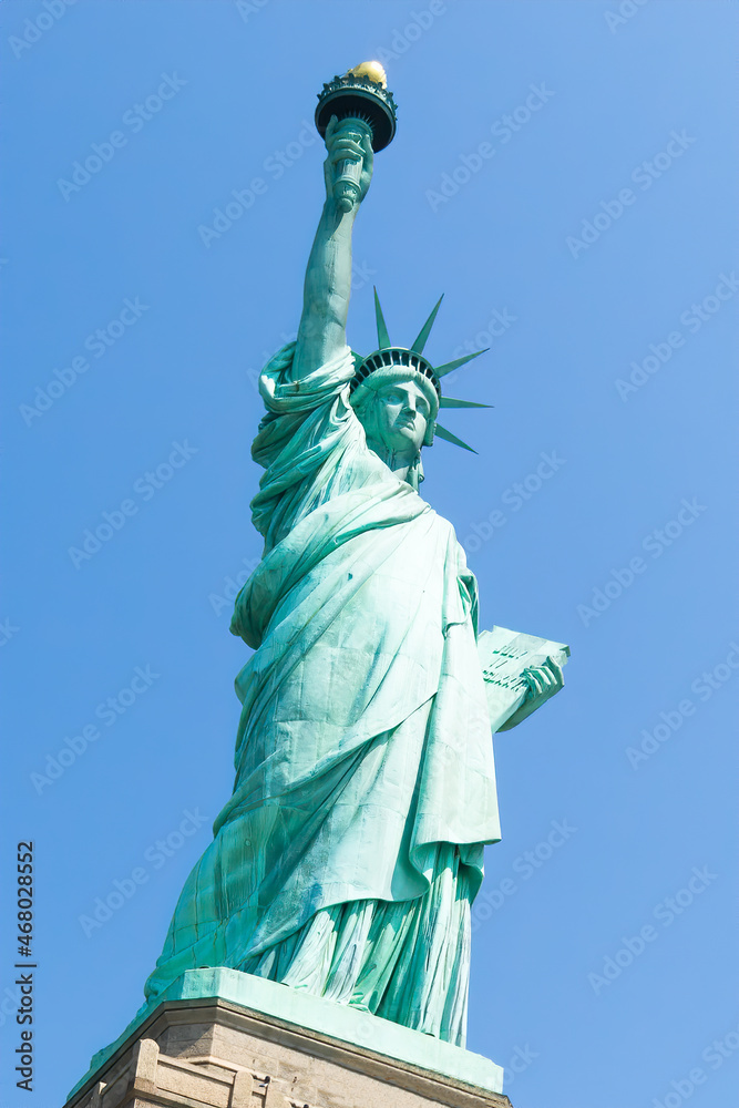 Fototapeta premium Low angle view of statue of liberty with blue sky during sunny day in summer. Liberty Island, New York. United States.