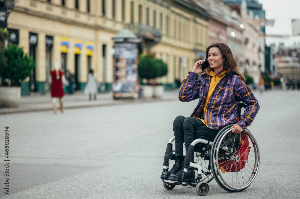 Naklejka premium Woman with disability using a smartphone while out in the city