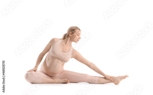 Beautiful young pregnant woman practicing yoga on white background