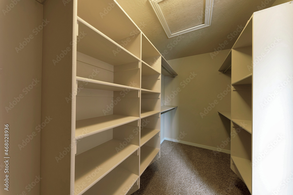 Empty walk-in closet with framed shelves and metal rods Empty walk-in closet with framed shelves and metal rods