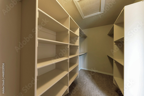 Empty walk-in closet with framed shelves and metal rods
