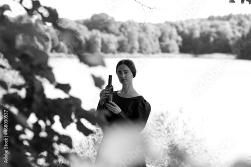 Woman in dress with a bottle of wine in black and white