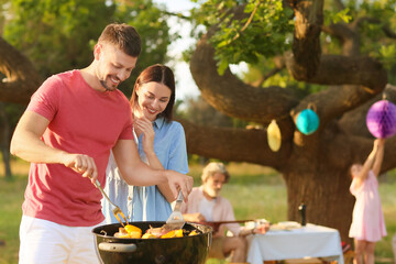 Happy family at barbecue party on summer day