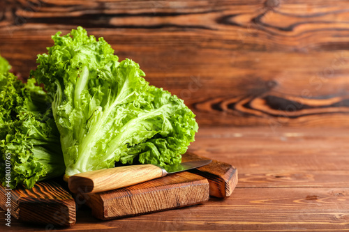 Canvastavla Board with fresh lettuce and knife on wooden background, closeup