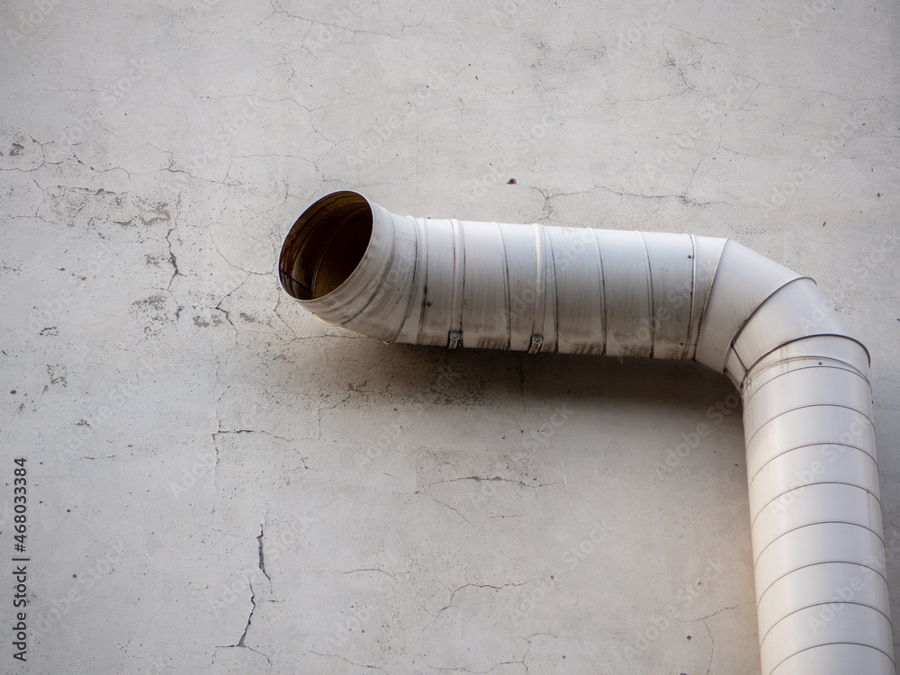 Cylindrical curved pipe on a concrete wall Cylindrical curved pipe on a concrete wall