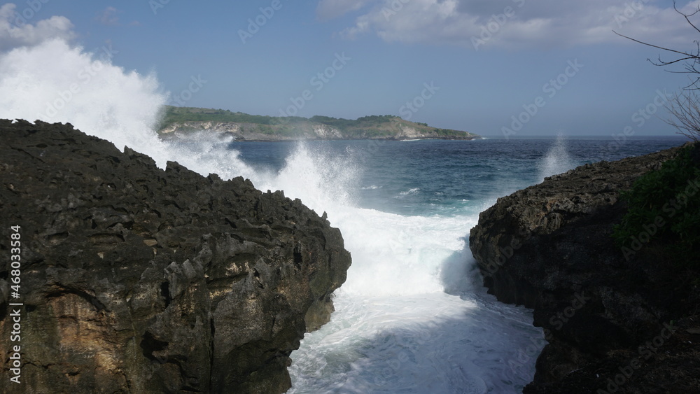 Waves force rain sea water crashing on rocks coast beach sky spectacle nature ocean Angel Billabong Indonesia place destination for vacation travel summer heat sunny days