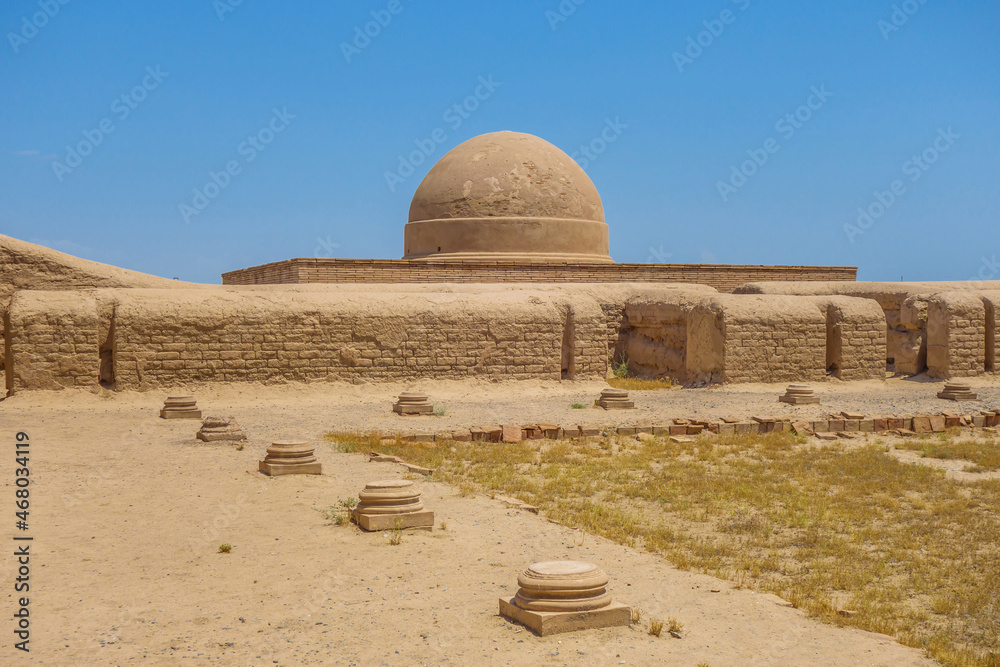 Column hall of the Buddhist monastery Fayaz Tepe, Termez, Uzbekistan. The bases of the columns are visible. A dome with a stupa is visible in the background. The monastery was built in the 1-2 century