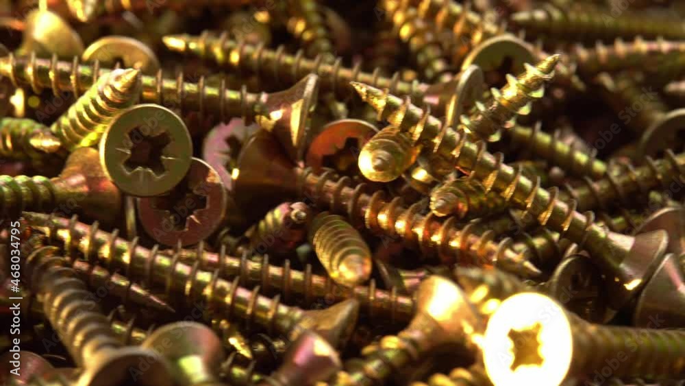 Golden screws or cross head screws rotate like background, construction supplies self-tapping screws or bolts Golden screws or cross head screws rotate like background, construction supplies self-tapping screws or bolts