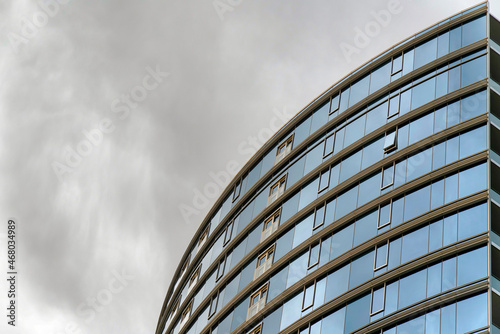 Low angle view of a curved building with windows and tinted reflective curtain walls at Utah