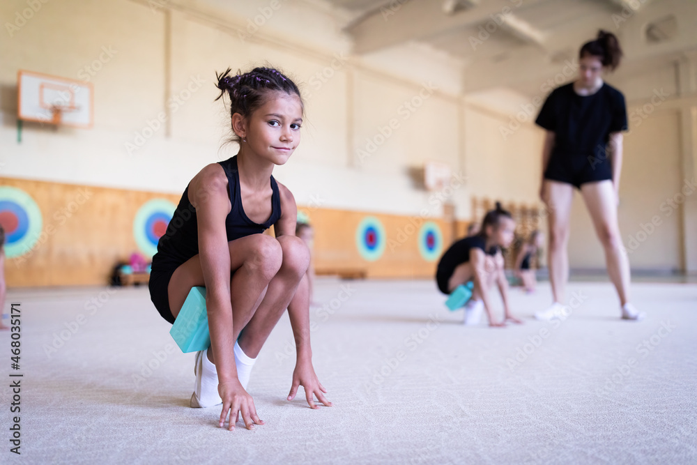 Obraz premium Girl gymnast doing workout with fitness blocks on training in gym