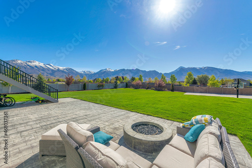 Fotografija Outdoor patio with a view of a large backyard with basketball court against the