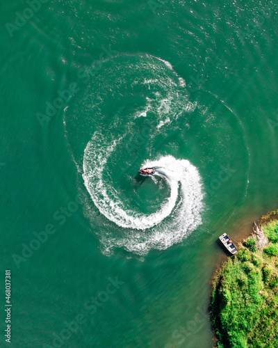 jet ski doing a 360 from above with a small patch of land in aerial frame © Aon Prestige Media
