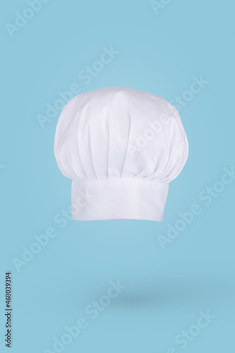 Chef hat floating in air isolated on a blue background. Creative business concept.