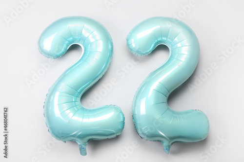 Figure 22 made of green balloons on light background