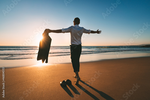 Life is good. Man with open arms enjoying life and freedom on the beach with sunset
