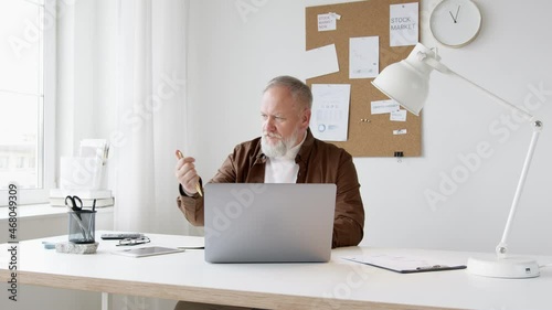 man works in an office with a laptop.