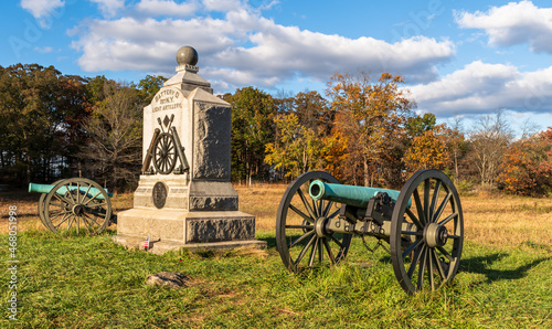 A Union monument and civil war cannons in the Wheatfield on the Gettysburg National Military Park on a sunny fall day photo