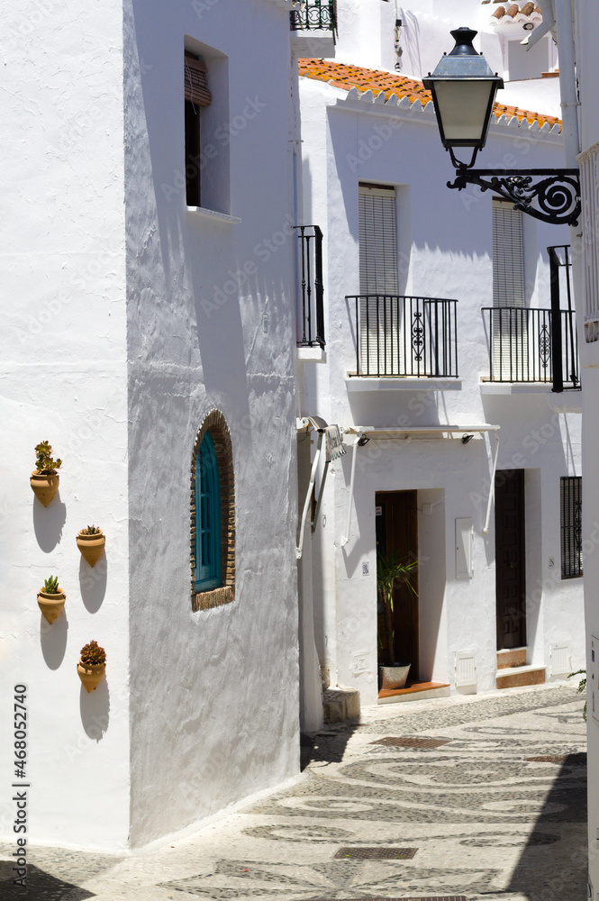 Beautiful Frigiliana village, southern Spain. Charming pretty alley. Traditional architecture with old fashioned white painted town houses.  Vertical shot.