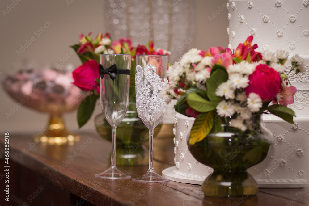 Bride and groom cup on the table with flowers in background wedding day Bride and groom cup on the table with flowers in background wedding day