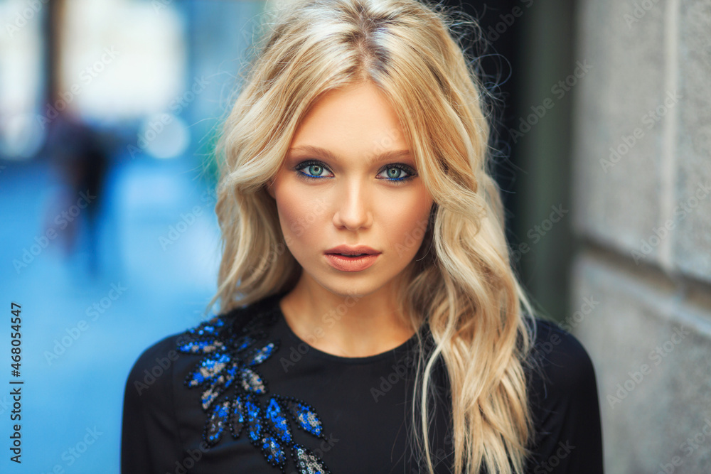 Attractive young blonde girl walking in long black evening dress outdoors Attractive young blonde girl walking in long black evening dress outdoors