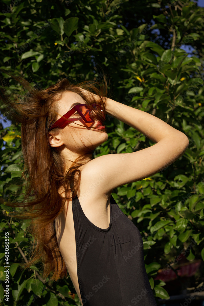 Fototapeta premium pretty woman wearing sunglasses green leaves summer model