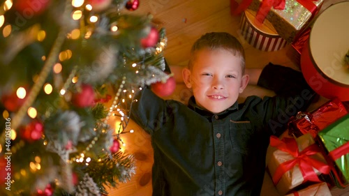 Merry Christmas. A happy child lies under the tree next to gifts and dreams. Happy new year. childhood dream concept